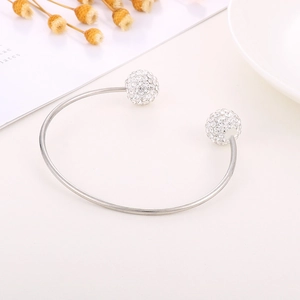 Close-up of silver titanium steel open C-ring bangle with sparkling rhinestone spheres