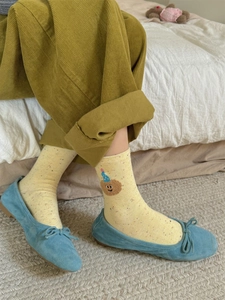 Detail of yellow cotton crew socks with colorful speckles and cute bear embroidery