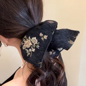 Classic black floral embroidered bow scrunchie with jacquard texture for elegant hairstyling