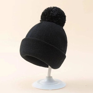 Classic black knit beanie for kids featuring a cozy pom-pom and wide ribbed cuff