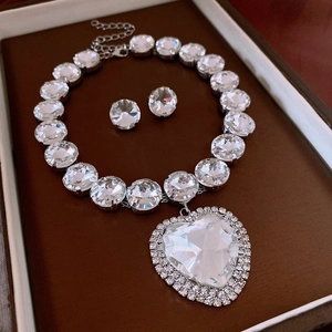 Detailed view of silver heart pendant necklace and stud earrings set in gift box