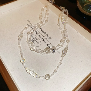 Detail showing transparent layered crystal beads with iridescent shimmer on a display tray