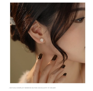Close-up of a model wearing a delicate 999 sterling silver rose flower earring in silver finish
