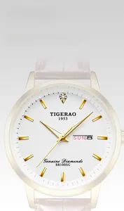Close-up of gold quartz watch with white textured dial and date-day window display