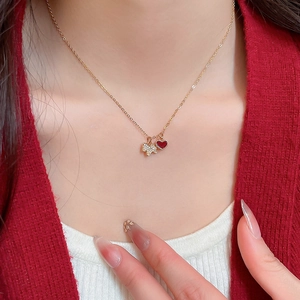 Gros plan d'un collier doré avec pendentif cœur rouge et étoile étincelante sur un mannequin