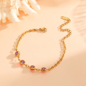 Detail of 18k gold plated stainless steel bracelet with purple round gemstones