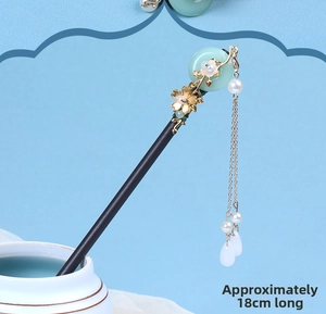 Detail of traditional Chinese black wooden hair pin with green faux jade and 18cm length