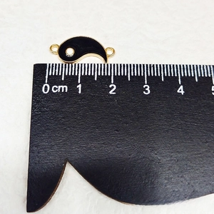 Detail shot showing the dimensions of the Tai Chi Yin Yang charm with a ruler measurement