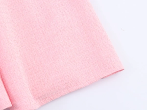 Detailed macro view of pink tweed fabric texture and stitching on the French style dress