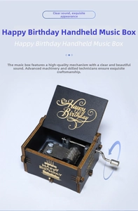 Detailed view of hand-crank wood music box with Happy Birthday engraving and metal movement