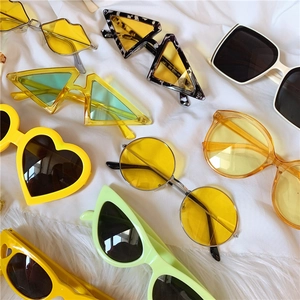 Flat lay of colorful vintage daisy flower square sunglasses on white fabric texture