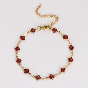 Detail of a gold stainless steel bracelet with square reddish-brown glitter resin inlays