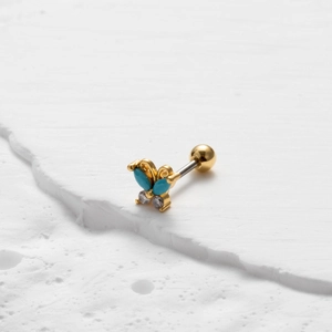 Detailed view of golden butterfly earring with blue turquoise and clear zircon stones
