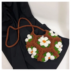 Detail of handmade crochet puff flower crossbody bag with pearl clasp and daisy patterns