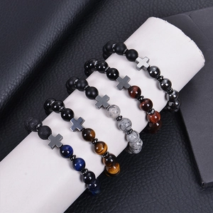 Natural stone beaded bracelets with metal cross pendants on a cylindrical display