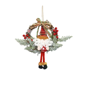 Christmas pine needle wreath with Santa doll and red berries for festive door decoration