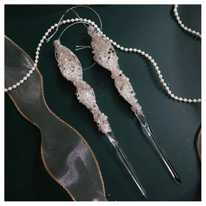 Close-up of sparkling Christmas icicle ornaments with sequins on deep green background
