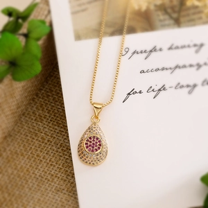 Elegant 18K gold plated necklace with a red teardrop zircon pendant on a textured background