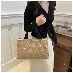 Close-up of khaki quilted puffer tote bag with elegant diamond stitch pattern and soft finish