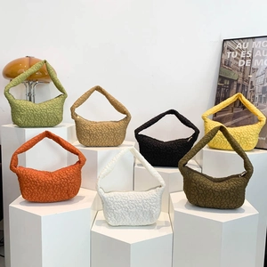Minimalist bubble textured shoulder bags in seven colors displayed on white pedestals