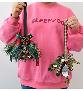 Detail of Christmas ornaments with pine cones, Santa head, and festive ribbons