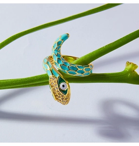 Detail of snake ring with blue enamel and evil eye zircon on green plant stem