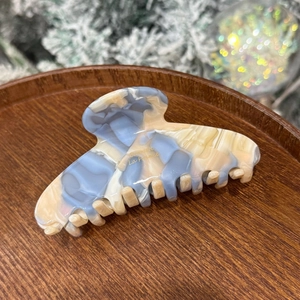 Detail of blue and beige marble acetate hair claw with gold Barrette La France text