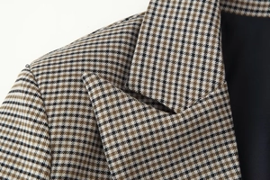 Macro detail of houndstooth plaid pattern on blazer shoulder and notched lapel