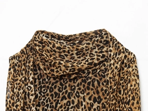 Detail of leopard print fabric featuring a cowl neck draped design on woman dress