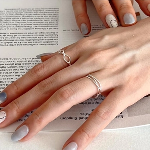 Close-up of S925 sterling silver twisted heart and layered ring set on hand