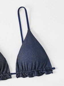 Détail macro du haut de bikini bleu foncé scintillant avec volants et texture métallique
