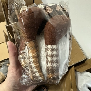 Détail d'une poupée Rudolf en peluche avec des textures tricotées brunes et blanches