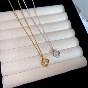 Macro shot of 18k gold plated and silver square pendants with zircon stones on velvet tray