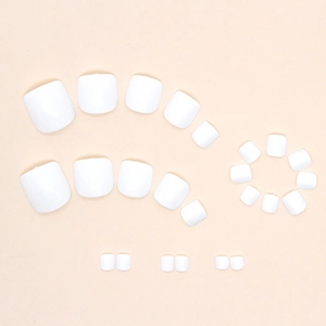 Glossy milky white press-on toenails set with multiple sizes arranged in a curve