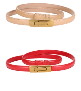 Detail of slim beige and red leather belts with gold rectangular buckles for dresses
