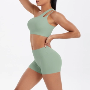 Detail of light green one-shoulder sports bra and high-waist shorts set for yoga fitness