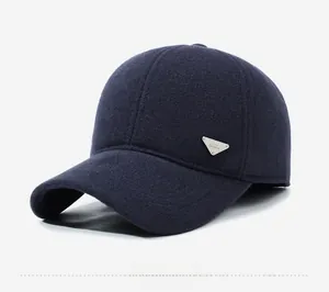 Detail view of the silver triangular metal plaque on a warm navy wool baseball cap