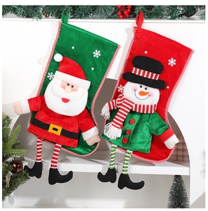 Detail of plush Santa and Snowman long-leg Christmas socks hanging by pine needles