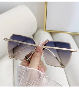 Detail view of oversized rimless geometric sunglasses with purple gradient lenses