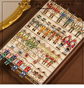Detail of nutcracker soldier earrings with enamel finish and pearl accents in a tray