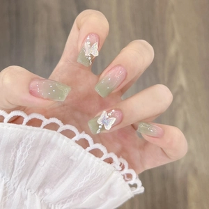 Detail of square pink green gradient press-on nails with 3D butterfly and pearls