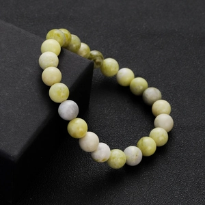 Macro detail of natural stone beaded bracelet with light green and beige round beads