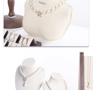 Macro detail of walnut jewelry stand showcasing pearl necklaces and flower earrings