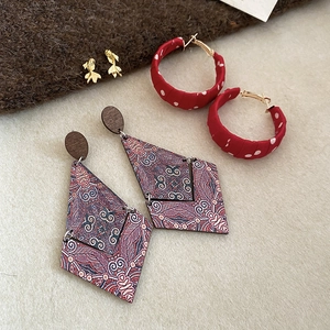 Detailed macro view of vintage geometric pearl earrings with fabric and wood details