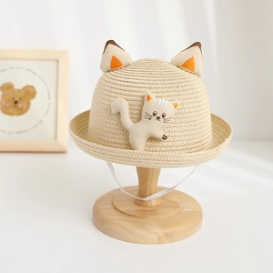 Detail of children's straw sun hat featuring 3D cat ears and cute plush kitten patch