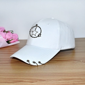 Close-up of white cotton baseball cap with metallic star pendant and metal rings decoration