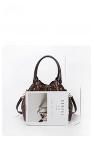 Detailed view of bucket bag with geometric print, showing sturdy handles and long strap