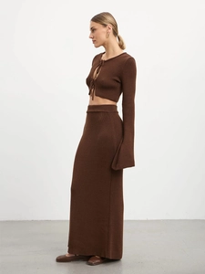 Detail of dark brown knit two-piece set featuring lace-up cardigan and long slit skirt