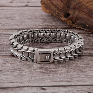 Retro antique silver dragon bone chain bracelet with square clasp on wood surface