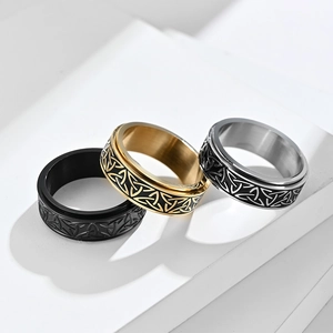 Nordic Celtic knot spinner rings in black, gold, and steel finishes on stone display
